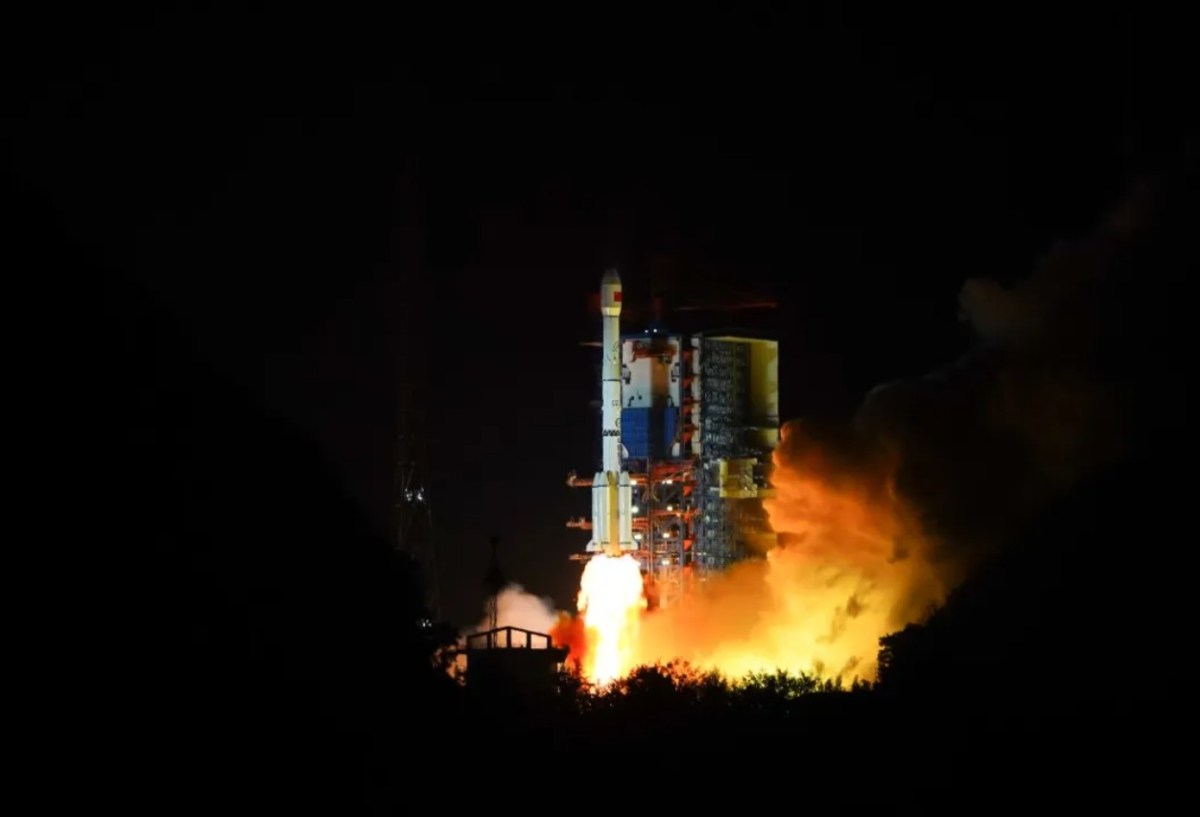 A Long March 3B rocket lifts off from Xichang Satellite Launch Center at night, illuminating the launch pad with bright orange exhaust flames during the launch of the classified TJS-17 satellite on April 10, 2025.